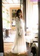 A woman in a white dress standing in a room.