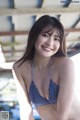 A woman in a blue bikini posing for a picture.