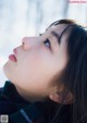 A woman with long black hair looking up at the sky.