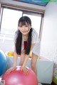 A young woman is posing on an exercise ball.